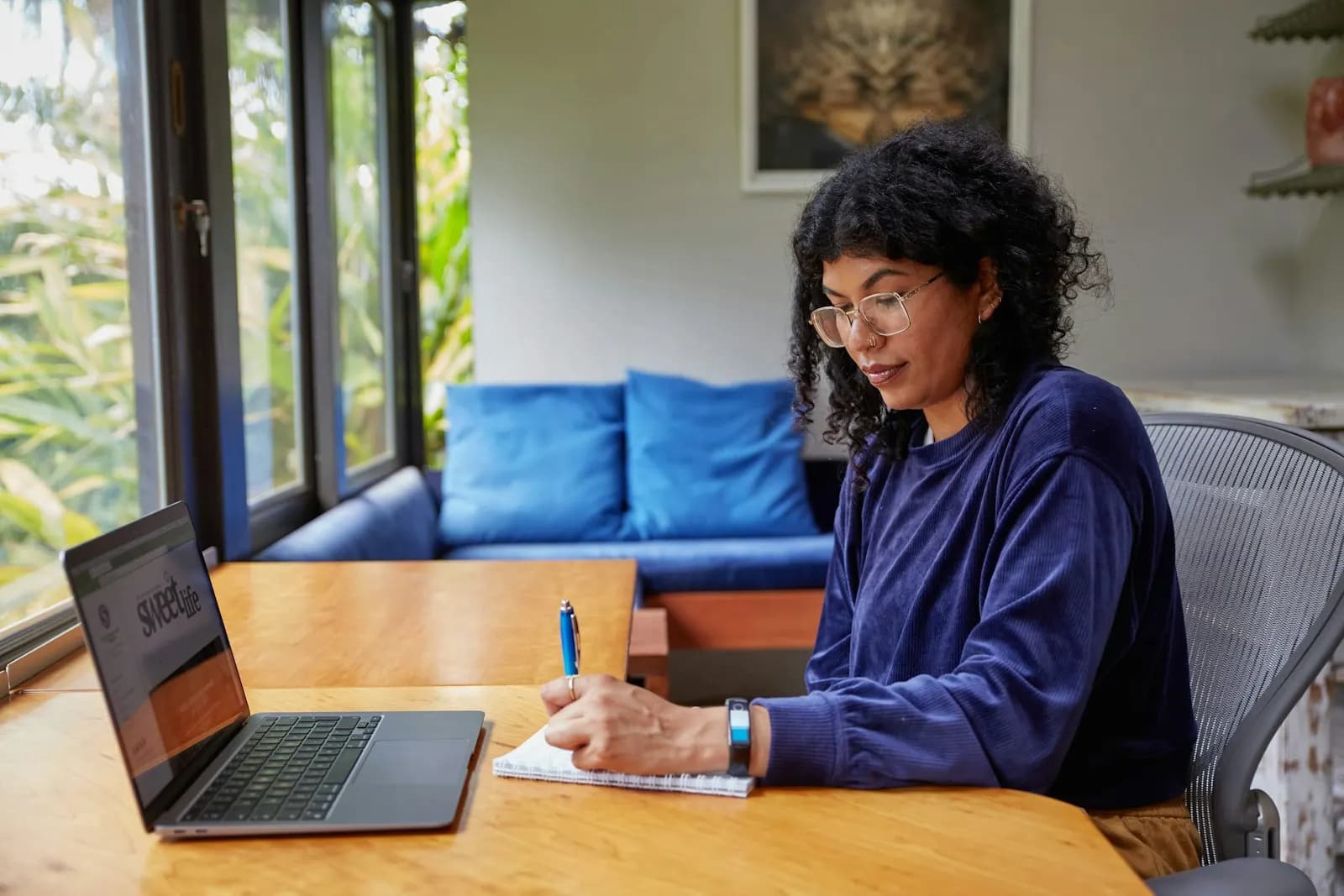 Profesional trabajando con su computadora portátil y tomando notas en su escritorio